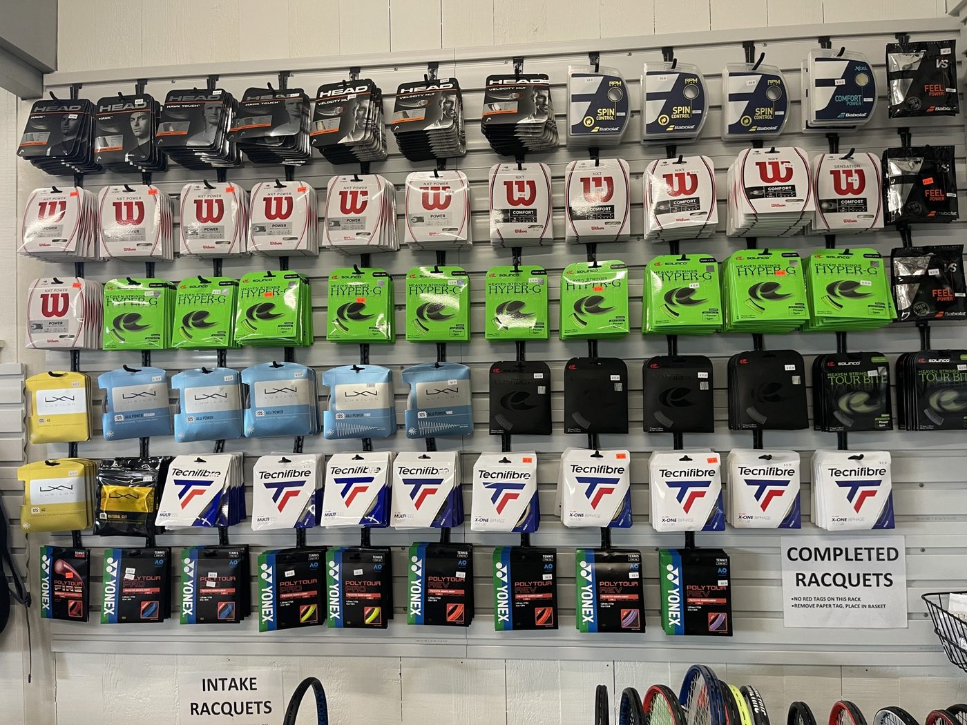 Inside the pro shop, rackets and bags lining the walls