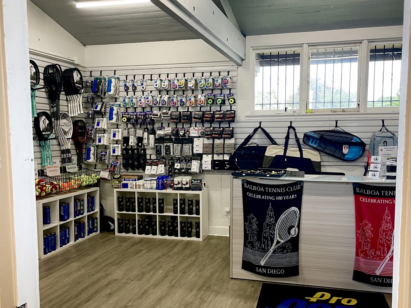 Strings, grips and racket accessories on the wall of the HJK pro shop